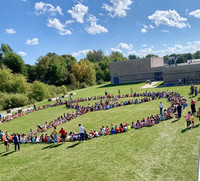 Students congregate to form a peace sign on the GES lawn