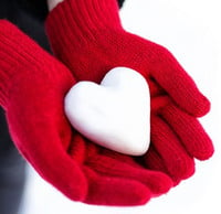 Red gloves holding a white heart