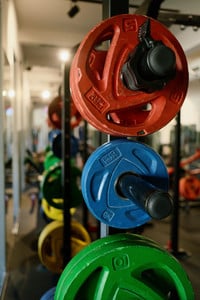 Barbells with plate weights in different sizes in green, blue and red.